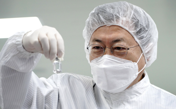 문재인 전 대통령이 2021년 1월 당시 SK바이오사이언스 공장 코로나19 백신 완제 제조실에서 분류중인 아스트라제네카 백신(위탁 생산분)을 들어보이고 있다. (문 전 대통령 페이스북 캡처)